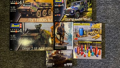 Sammlung von Plastikmodellbausätzen mit militärischen Fahrzeugen und Zubehör.