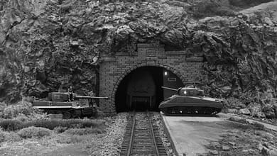 Diorama: Tiger- und Sherman-Panzer vor Gebirgstunnel mit Gleisen.