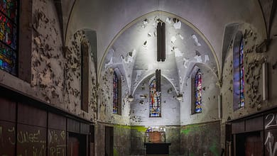 Verlassene Kirche mit Graffiti und bröckelndem Putz.